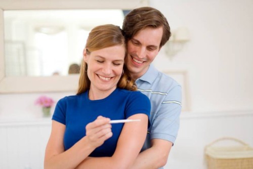 Happy man and woman with pregnancy test