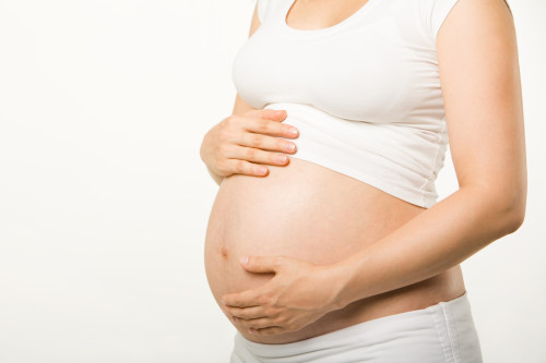 Image of pregnant woman touching her belly with hands