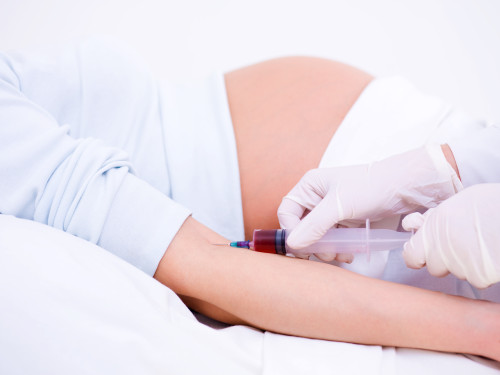 Doctor takes blood on the analysis from the pregnant woman
