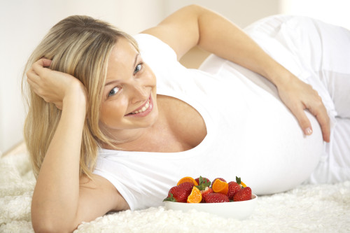 young pregnant woman with fresh fruits