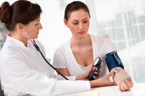 Female doctor checking young woman blood pressure; Shutterstock ID 110814176; PO: The Huffington Post; Job: The Huffington Post; Client: The Huffington Post; Other: The Huffington Post