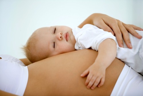 Baby sleeping on pregnant woman's stomach