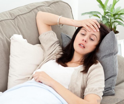 woman-on-gray-couch-looking-nauseous-and-sick