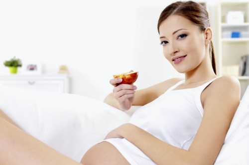 pregnant woman eating fresh red apple