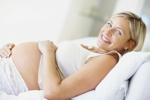 Happy and healthy pregnant woman on the couch