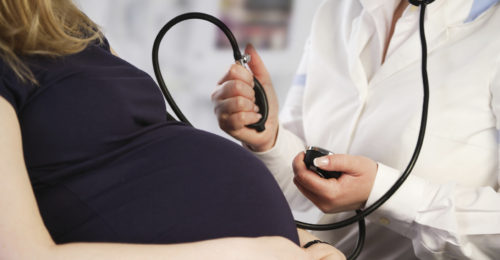 Pregnant woman having her blood pressure checked by the doctor
