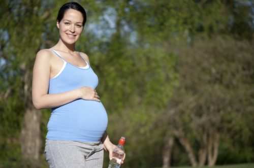 Pregnant woman holding water bottle