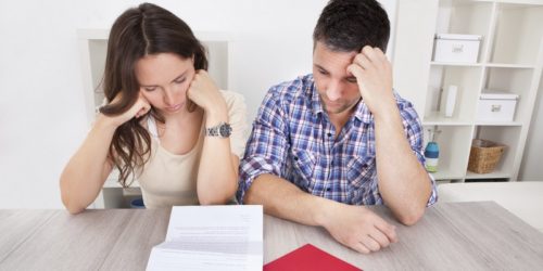 Worried Couple Reading Paper