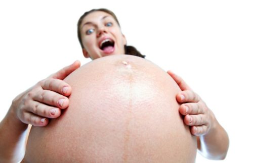 Pregnant woman with hands over tummy